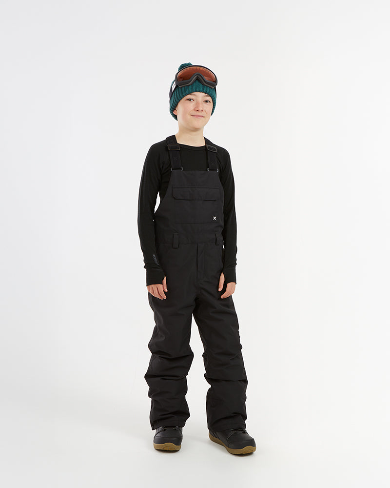 XTM Kids Bailey Ski Pant in Black, front view on a child, bib cut with shoulder straps