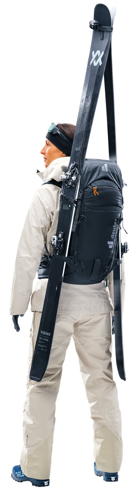 Skier wearing the Deuter Freescape Tour 30 SL with skis carried vertically at the side