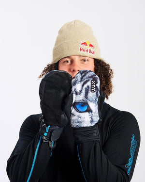 Rider holding XTM Snow Leopard mitts to his face, one showing the suede palm and one the print