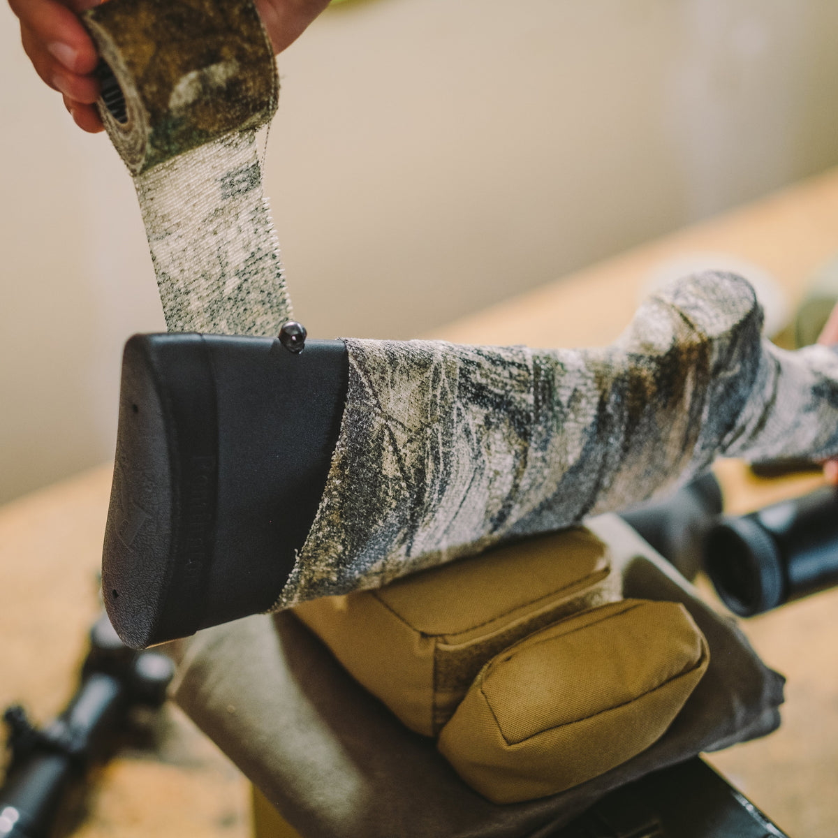 Camo Form being wound around a rifle stock just ahead of the recoil pad
