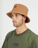 Man wearing the XTM Sundew hemp-cotton bucket hat in Woodsmoke tan, three-quarter view