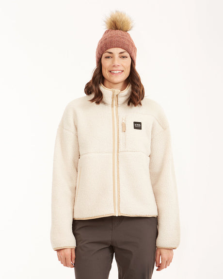 Woman wearing XTM Banksia sherpa fleece jacket in Bone cream, front view zipped up with chest badge
