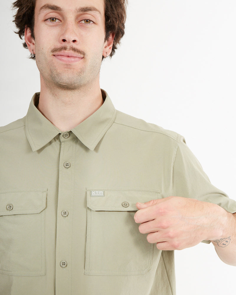Hand at the chest pocket of the Light Khaki XTM Dunkeld short sleeve shirt