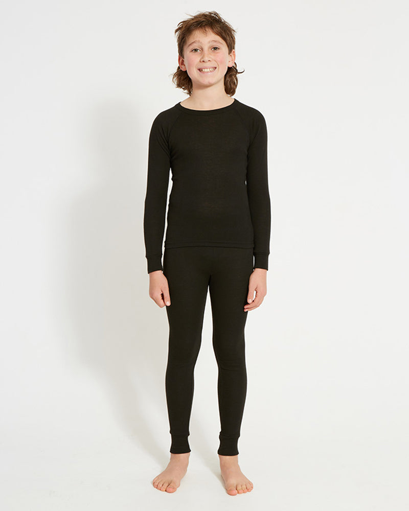 XTM Kids Heatflex Thermal Pant in Black, full-length view on a boy with a matching top