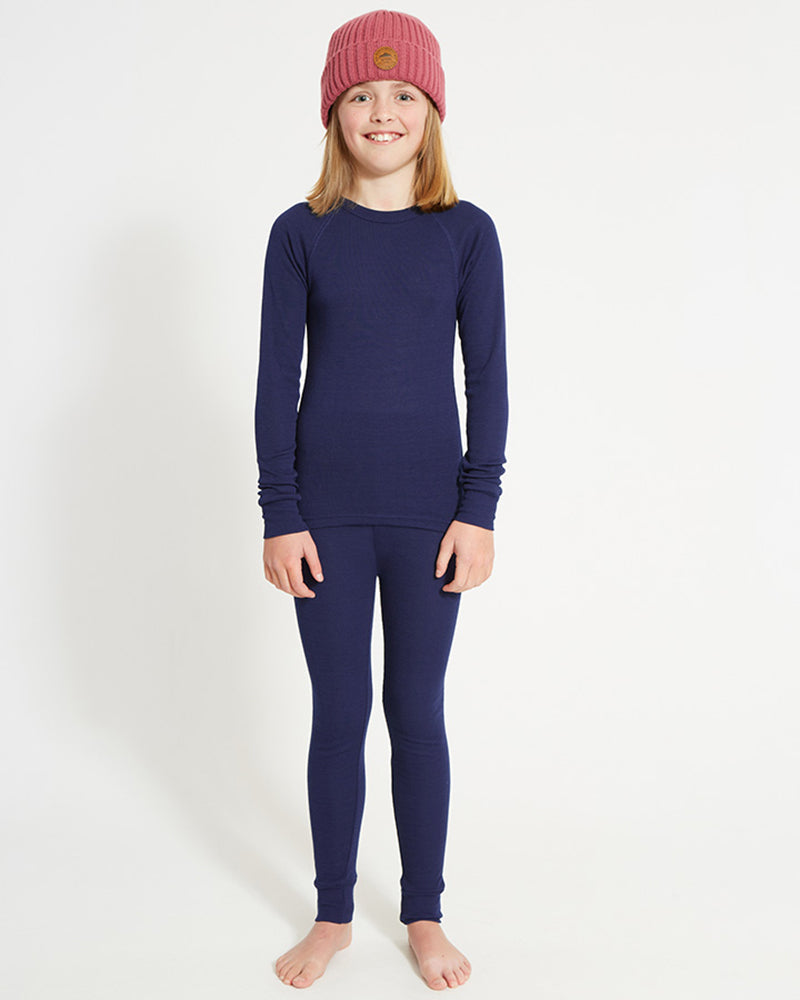 XTM Kids Heatflex Thermal Pant in Navy, full-length view on a girl with a matching top