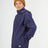 Boy in the XTM Kids Stash 2L rain jacket in Patriot Blue, hand in a side zip pocket