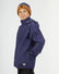 Boy in the XTM Kids Stash 2L rain jacket in Patriot Blue, hand in a side zip pocket