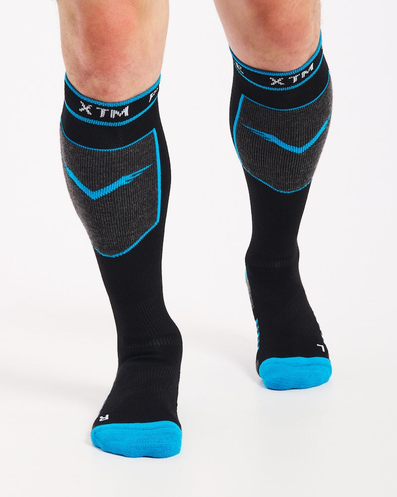 XTM Valentino technical snow socks in black with blue trim and grey shin panels, worn, front view