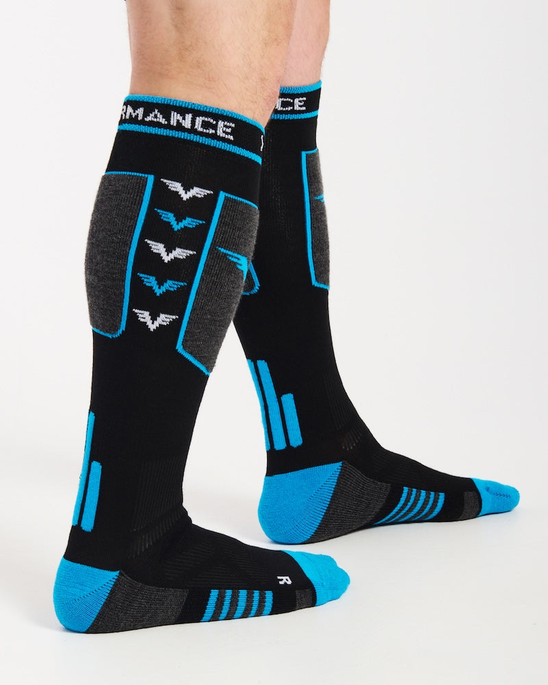 Side view of the XTM Valentino snow socks worn, with the blue and white V logos down the calf