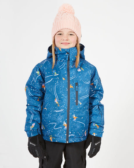 Girl wearing the Ski Nostalgia XTM Kids Snowcone Snow Jacket, blue with skier print, front view