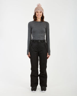Woman wearing the black XTM Smooch ski pants with a grey base layer, full-length front view