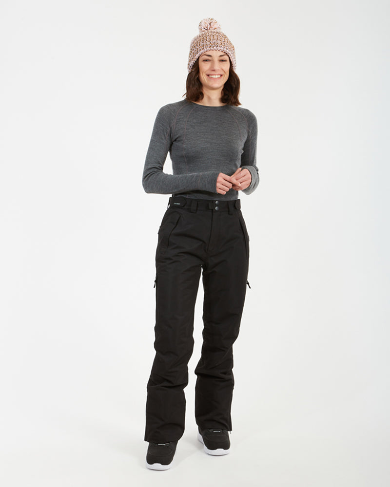 Woman smiling in the black XTM Smooch women's ski pants, full-length view