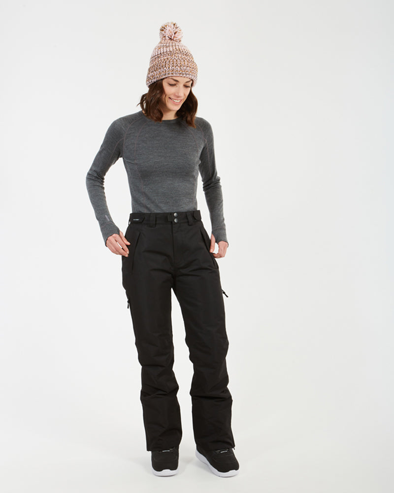Woman with hands at the waist of the black XTM Smooch ski pants, three-quarter view