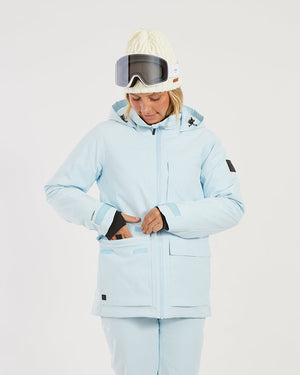 Close-up of a woman reaching into the front of the Sky Blue XTM Elevation II, thumb-hole cuff visible