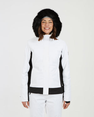 Woman in the white XTM Solace jacket with the black faux fur hood pulled up