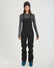 Woman wearing the black XTM Stellar 2.0 hardshell bib pant with ski boots, front view