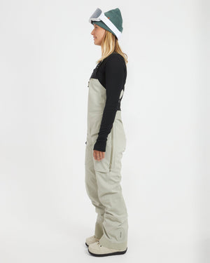 Side profile of a woman in the Stone Grey XTM Stellar 2.0 ski bib