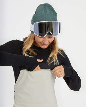 Woman opening the chest pocket on the Stone Grey XTM Stellar 2.0 bib