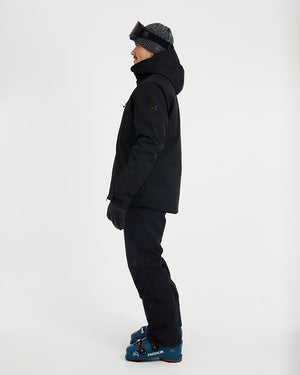 Side profile of the Black XTM Quantum snow jacket showing the hood and sleeve pocket