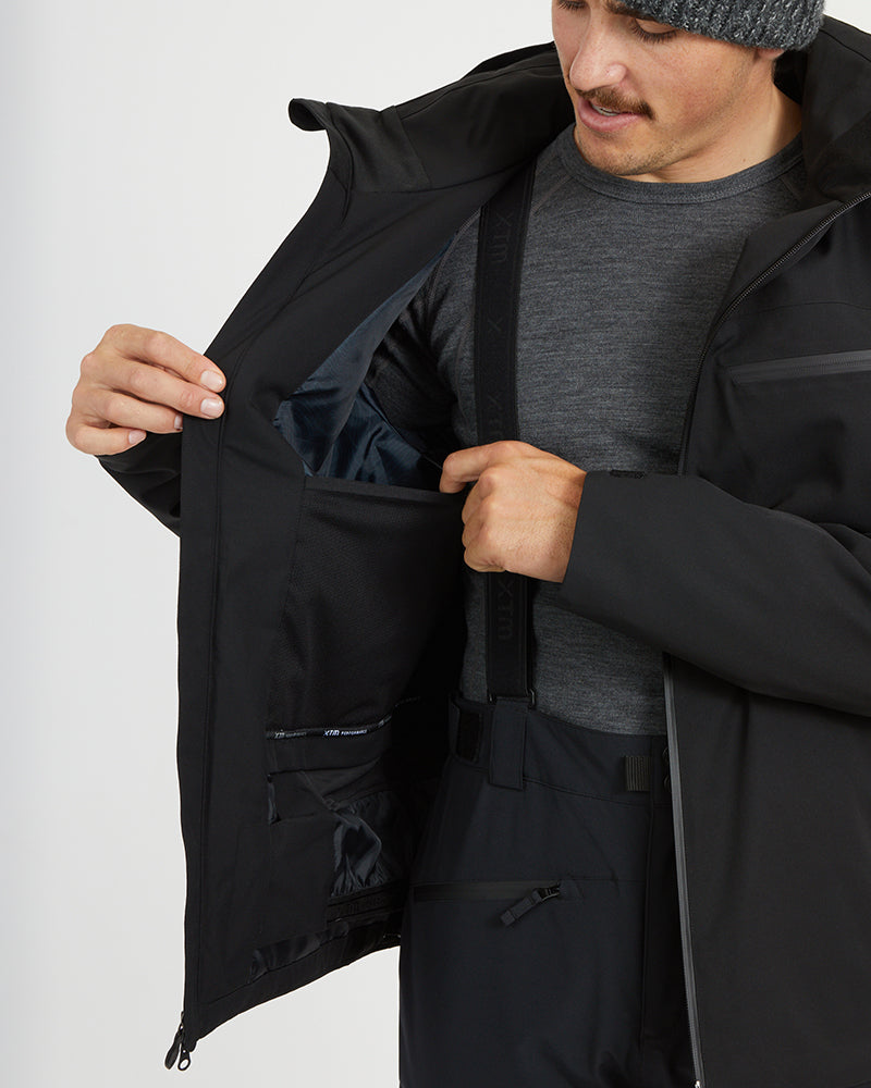 Black XTM Quantum jacket opened to show the internal pockets and powder skirt