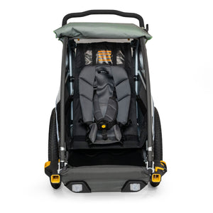 Burley Baby Snuggler fitted in a Burley trailer seat, front view with the harness buckled over it