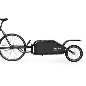 Burley Coho XC hitched behind a black bike, side view showing the single rear wheel and cargo frame