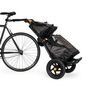Burley Travoy trailer hitched to a bike with the Upper Market Bag clipped on top and a second bag below
