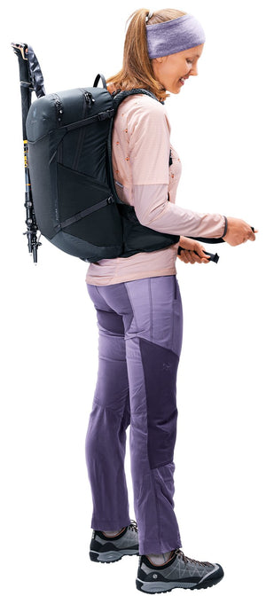 Walker wearing the Deuter Futura 25 SL in Black with trekking poles stowed on the side