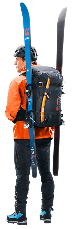 Skier in an orange jacket carrying skis on the side of the Deuter Jaypack Pro 34+14