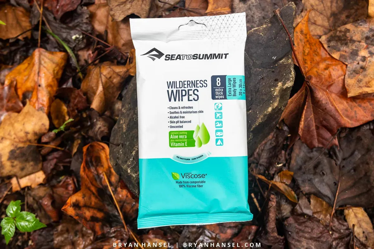 Wilderness Wipes 8 Pack lying on wet autumn leaves on the forest floor
