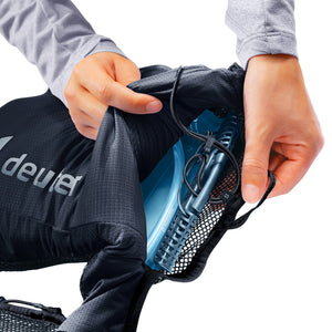 Hands sliding a hydration bladder into the rear compartment of the Deuter Traick 9