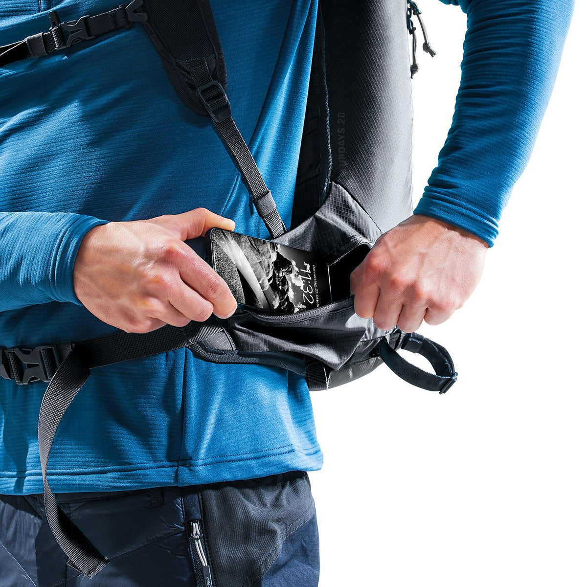 Ski tourer reaching into the bottom compartment of the Deuter Updays 20 while wearing it