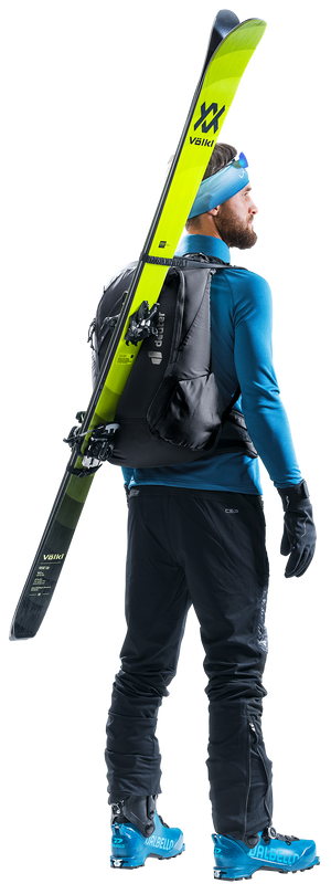 Ski tourer wearing the Deuter Updays 20 with skis carried diagonally