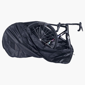 Road bike with its front wheel removed going into the open EVOC Bike Cover Road, wheel packed beside the frame