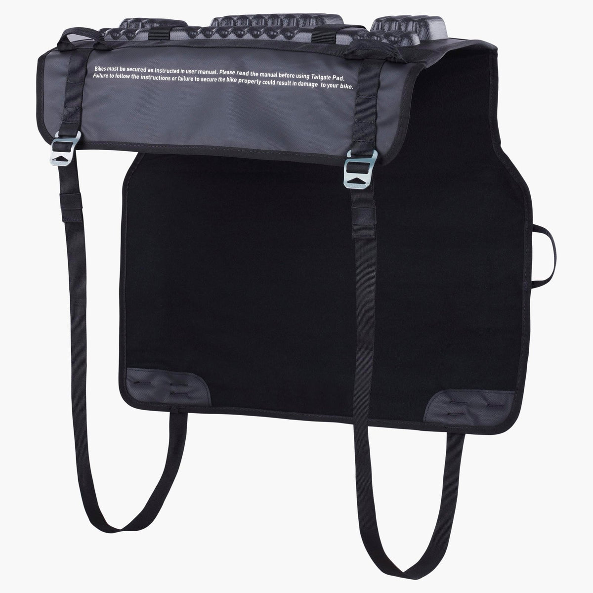 Inside of the black EVOC Tailgate Pad Duo: soft lining, buckled top straps and printed instructions