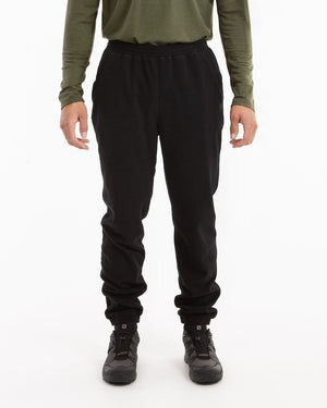 Man wearing XTM Tallows black Seawool fleece pants with elastic cuffs at the ankle, front view